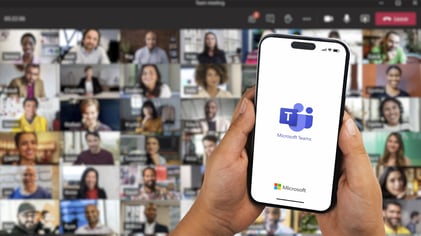 Teams phone with a background of people on a Teams meeting