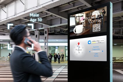 Man on phone looking at digital signage