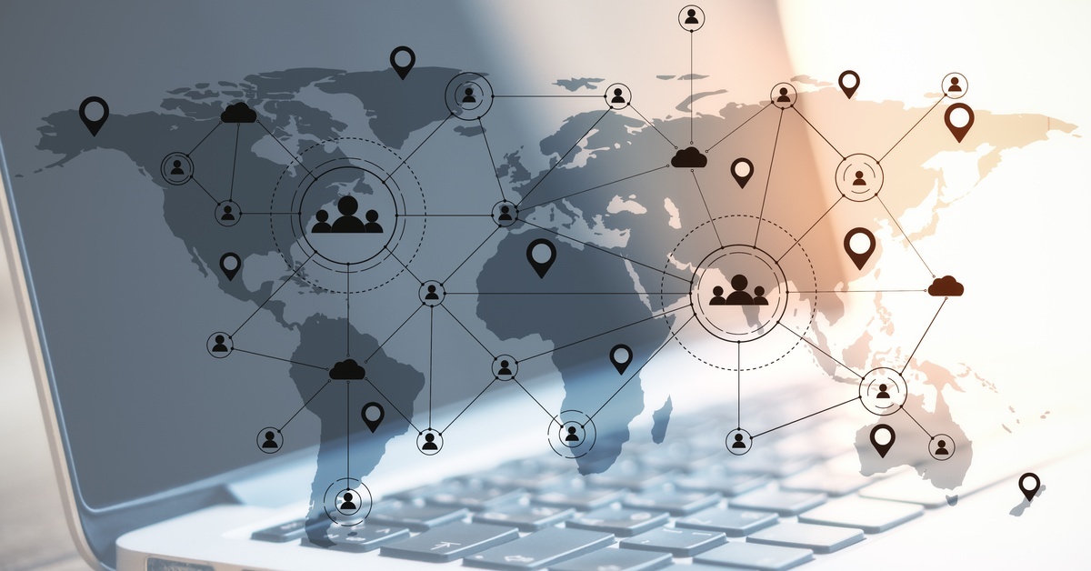 A world map superimposed over a blank laptop. The map features interconnected locations, people, and cloud symbols.
